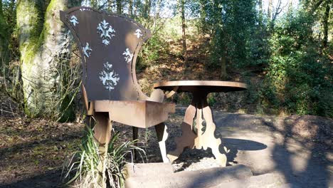 Fantasy-oversized-iron-decorative-royal-throne-and-table-in-secluded-woodland-forest-slow-left-dolly