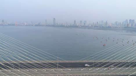 Volando-Sobre-El-Icónico-Puente-De-Enlace-Marítimo-Bandra-Worli-En-Mumbai,-Revelando-La-Vista-De-La-Ciudad-En-La-Parte-De-Atrás
