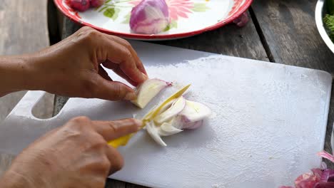 Finely-slicing-small-onion-on-white-chopping-board