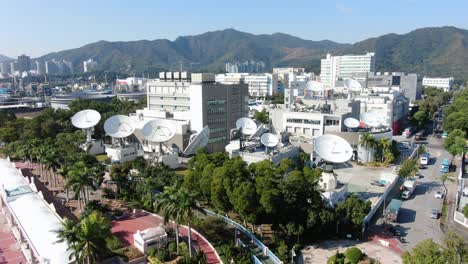 Cluster-of-Satellite-broadcast-Dishes-on-Asia-Pacific-Telecommunications-building-in-Hong-Kong-Tai-Po-area,-Aerial-view