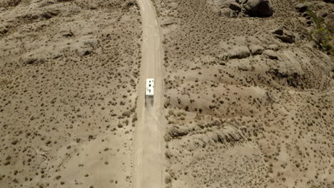 Drone-footage-of-off-road-track,-with-RV-driving-in-desert-with-mountains-in-Alabama-Hills-on-American-road-trip