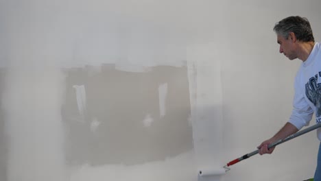 Adult-Male-Applying-Primer-to-Drywall---Paint-Roller-White-Paint---Construction