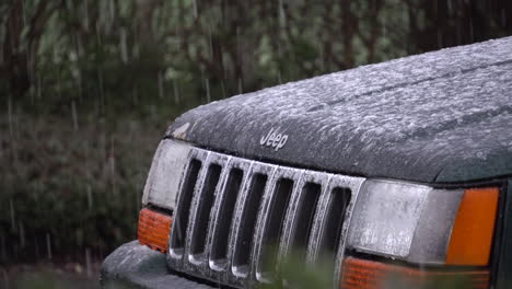 Front-grille-of-a-parked-jeep-in-the-slushy-snow