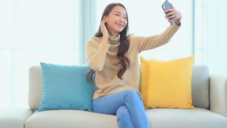 Young-Asian-Woman-Taking-Selfie-Photo-With-Smartphone-in-Home-Interior,-Slow-Motion