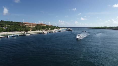 Vista-De-Drones-De-Un-Yate-Navegando-Cerca-De-Un-Resort-En-Curaçao
