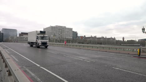 4k-shot-of-a-key-worker,-lorry-driver,-passing-an-empty-Westminster-Bridge-during-the-pandemic-and-lockdown
