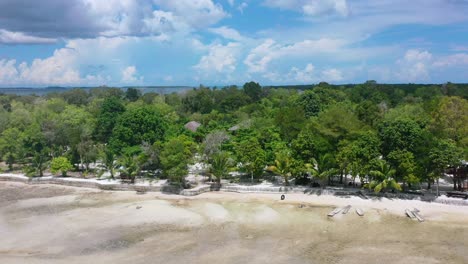 aerial-slow-motion-of-green-trees-along-empty-coastline-beach-on-Leebong-private-island-during-low-tide-on-a-sunny-day-Belitung-Indonesia