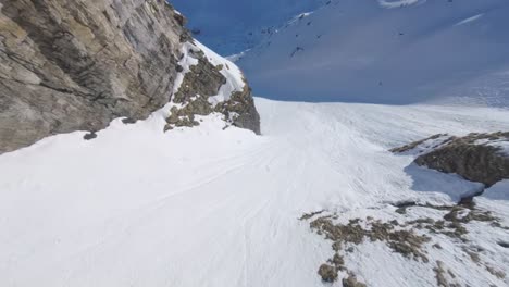 Atemberaubende-Fpv-renndrohne-Aus-Der-Luft,-Die-Die-Schneebedeckte-Bergkette-In-Der-Schweiz-Hinuntertaucht