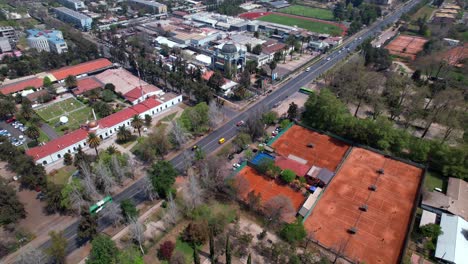 Topdown-view-of-clay-tennis-courts-of-Quinta-Normal-Park,-Drone-towards-Artequin-Museum