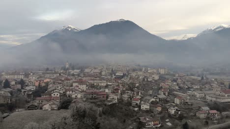 Aerial-view-of-small-town-Tolmin-in-Slovenia-on-cold-misty-winter-morning