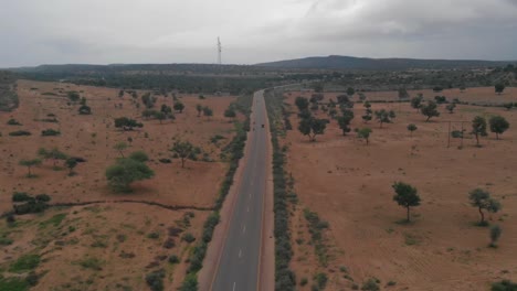 Drone-takes-upward-vertical-shot-of-the-highway-of-Tharparkar-which-is-located-in-Sindh-where-very-vehicle-can-be-seen-moving