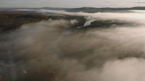 Fliegen-Sie-über-Wolkendach-über-Herbstlichen-Wald-Und-Fluss-In-Sherbrooke,-Quebec,-Kanada