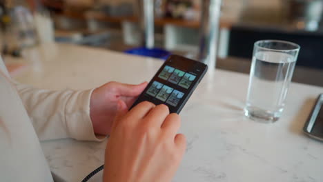Womans-hands-on-cell-phone-iPhone-typing-in-a-restaurant