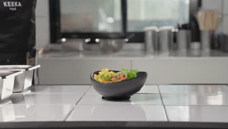 Person,-Die-Kimchi-In-Eine-Schüssel-Mit-Frischen-Grünen-Salatblättern-Legt