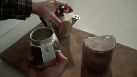 Männchen,-Das-Eine-Bialetti-Moka-Express-Kaffeemaschine-öffnet,-Um-Morgens-Kaffeepulver-In-Den-Filter-Zu-Geben