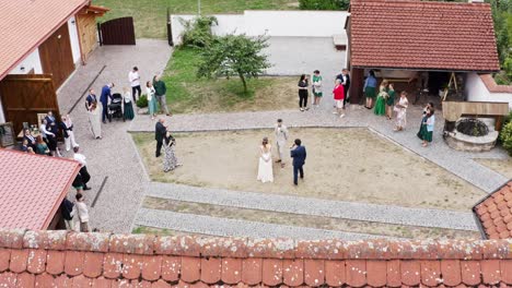 Best-man-interviewing-newlywed-couple-at-homestead-wedding,-drone-shot