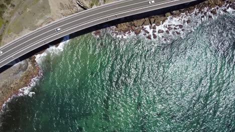Aerial-drone-shot-of-sea-cliff-bridge-and-water