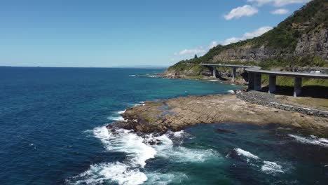 Flying-over-water-next-to-a-sea-cliff-bridge