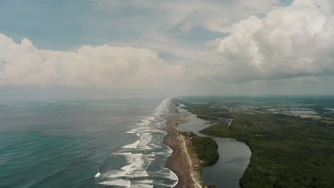 Vista-Aérea-De-Las-Olas-Del-Océano-En-La-Playa-A-Lo-Largo-Del-Río-Acome-Y-El-Parque-Nacional-Sipacate-naranjo-En-El-Paredón,-Guatemala
