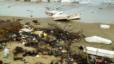 Giant-pieces-of-styrofoam-are-washed-ashore,-plastic-parts-are-lying-on-the-beach,-an-immensely-polluted-place
