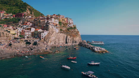 Cinque-Terre-Mit-Den-Dörfern-Monterosso,-Vernazza,-Corniglia,-Manarola-Und-Riomaggiore-An-Der-Mittelmeerküste-Italiens-Mit-Fischerboot-Und-Schwimmenden-Touristen