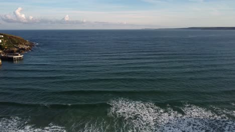 Aerial-shot-of-waves-coming-in-to-shore-moving-back-on-Newquay-beach,-Cornwall,-England,-Uk