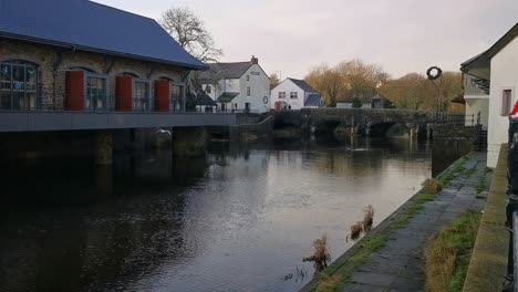 Seagulls-flying-around-a-river-flowing-through-a-rural-town-centre,-in-Haverfordwest,-West-Wales