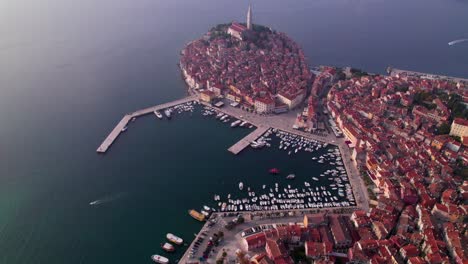 Ancient-city-Rovinj-with-harbor-at-Adriatic-Sea-during-hazy-day,-aerial