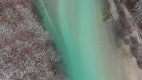 Die-Drohne-Erhebt-Sich-An-Einem-Kalten-Wintermorgen-über-Dem-Wunderschönen-Kristallklaren-Smaragdfluss