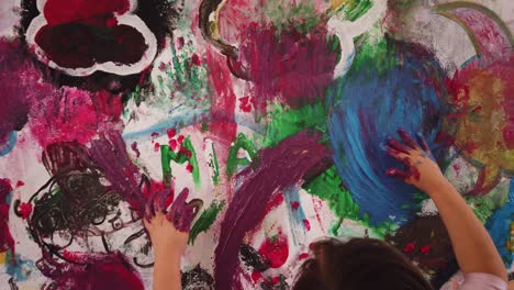 camera-in-youg-girl-hand-painting-with-creativity-a-wall-wearing-a-pink-dancing-outfit