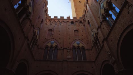 Atemberaubende-Aussicht-Vom-Hof-Des-Palazzo-Pubblico-Und-Seinem-Torre-Del-Mangia-Auf-Den-Muschelförmigen-Platz-Piazza-Del-Campo-In-Siena,-Toskana,-Italien