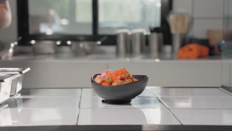 Adding-Pickled-Radish-Into-Salmon-And-Tuna-Poke-Bowl-On-The-Kitchen-Counter