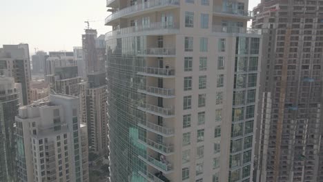 Man-taking-selfie-on-balcony-of-Residences-Tower-in-downtown-Dubai,-UAE,-aerial