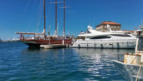 Mixture-of-yachts-and-boats-docked-in-a-marina-in-Zadar,-Croatia-in-summer-of-2020-with-blue-sky-and-clear-blue-water