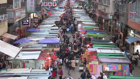 Fa-Yuen-street-market-stalls-as-large-crowds-of-shoppers-look-for-bargain-priced-vegetables,-fruits,-gifts,-and-fashion-goods-in-Hong-Kong