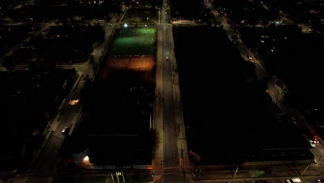 Aerial-view-group-of-people-playing-soccer-in-middle-class-neighborhood-at-night,-Santiago