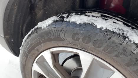 Close-shot-of-snow-over-the-tire-of-a-car