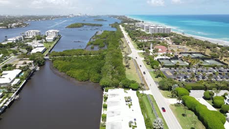 West-Palm-Beach,-Lake-Worth-Florida-barrier-island-turning-to-Ibis-Isle-neighborhood,-downtown-West-Palm-Beach-visible-in-the-background