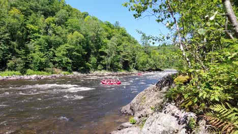 Group-of-people-in-3-rafts-rafting-on-a-mountain-river-during-a-sunny-day