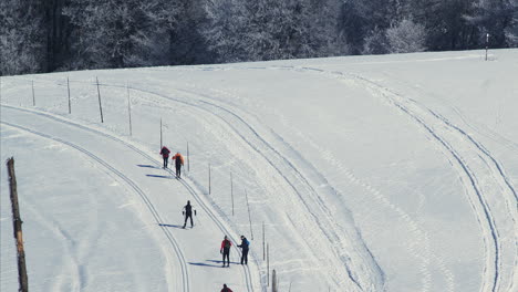 Aerial-View-of-Six-People-Skiing-Uphill-in-Stunning-Snowy-Winter-Landscape