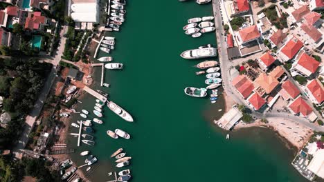 Flying-birdview-over-the-old-harbour-piers-and-ships-of-Spetses-greek-island-also-showing-houses-at-coastline