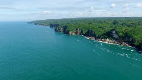Aerial-panorama-stunning-Kesirat,-Java-coast-cliffs-washed-by-calm-ocean-waves