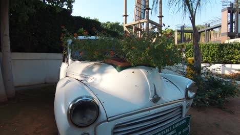 Antique-Car-transformed-into-garden-vase-in-Limassol-Municipal-Garden,-in-Cyprus---Wide-Orbit-Tracking-shot