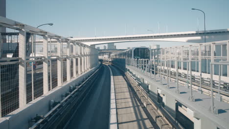 Eine-Point-of-View-Aufnahme-Einer-Yurikamome-Einschienenbahn,-Die-Sich-Entlang-Der-Einschienenbahn-Bewegt,-Während-Eine-Gegenüberliegende-Einschienenbahn-Kommt