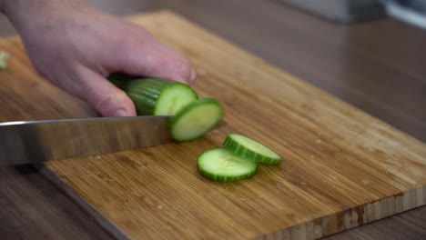 closeup-of-knife-slicing-cucumber-on-citchen-counter