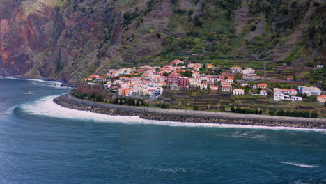 Aerial-view-around-waves-crashing-the-coast-of-the-Jardim-Do-Mar-town,-on-Madeira---circling,-drone-shot