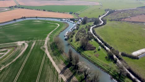 Drone-flies-above-the-River-Great-Stour-towards-a-curve,-sun-reflects-in-the-water