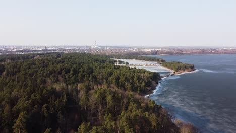 Beautiful-forest-and-Kaunas-lagoon-in-aerial-drone-view-on-early-spring