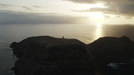 Silhouette-of-Lighthouse-on-Ilhéu-de-Ferro-with-bright-sunlight-at-dusk