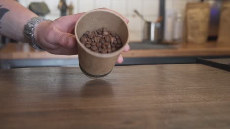 Hand-Verschüttet-Frisch-Braun-Geröstete-Kaffeebohnen-Auf-Holztisch